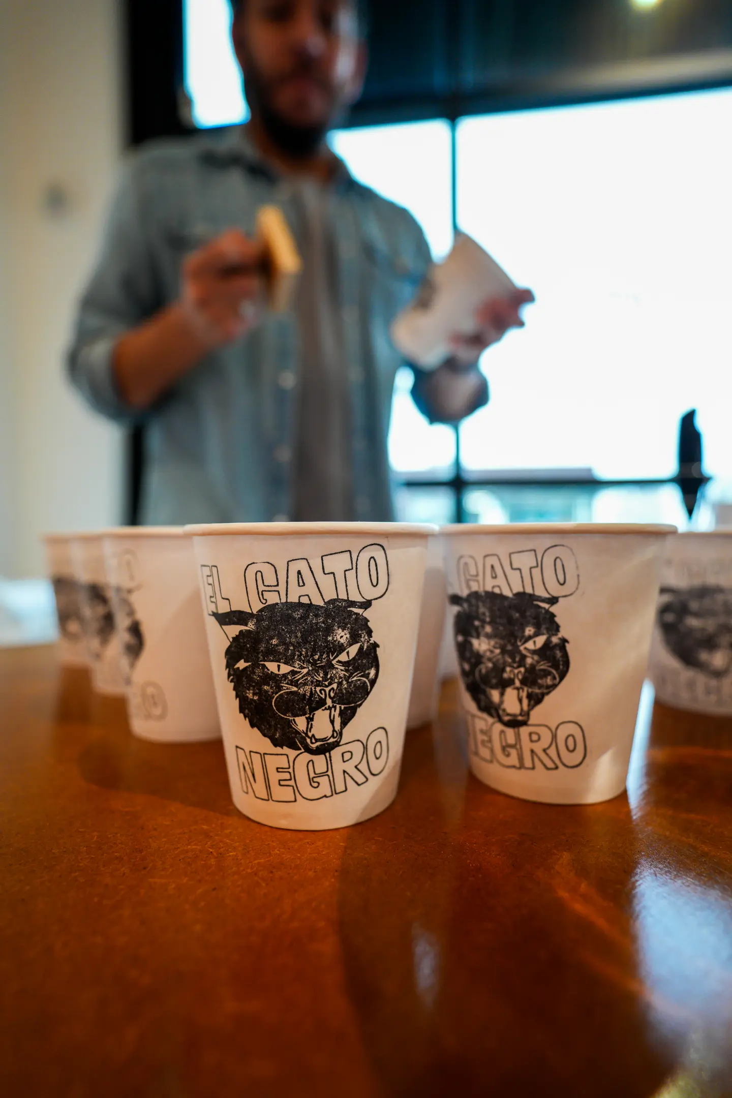 El Gato Negro branded cups lined up on a counter